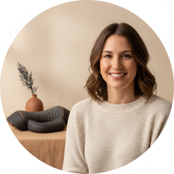 Portrait of Amanda Styles, a North American woman, smiling. She is wearing a smart-casual top against a clean, warm cream bac